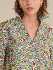 Woman wearing a floral patterned shirt with a neutral background
