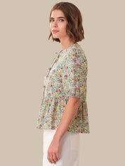Woman wearing a floral blouse against a beige background