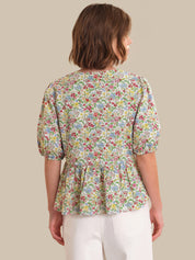 Woman wearing a floral blouse with a plain background