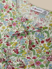 Floral fabric with colorful flowers and leaves, featuring a brand label.