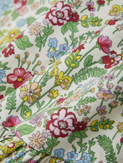 Close-up of a floral fabric with colorful flowers and leaves.