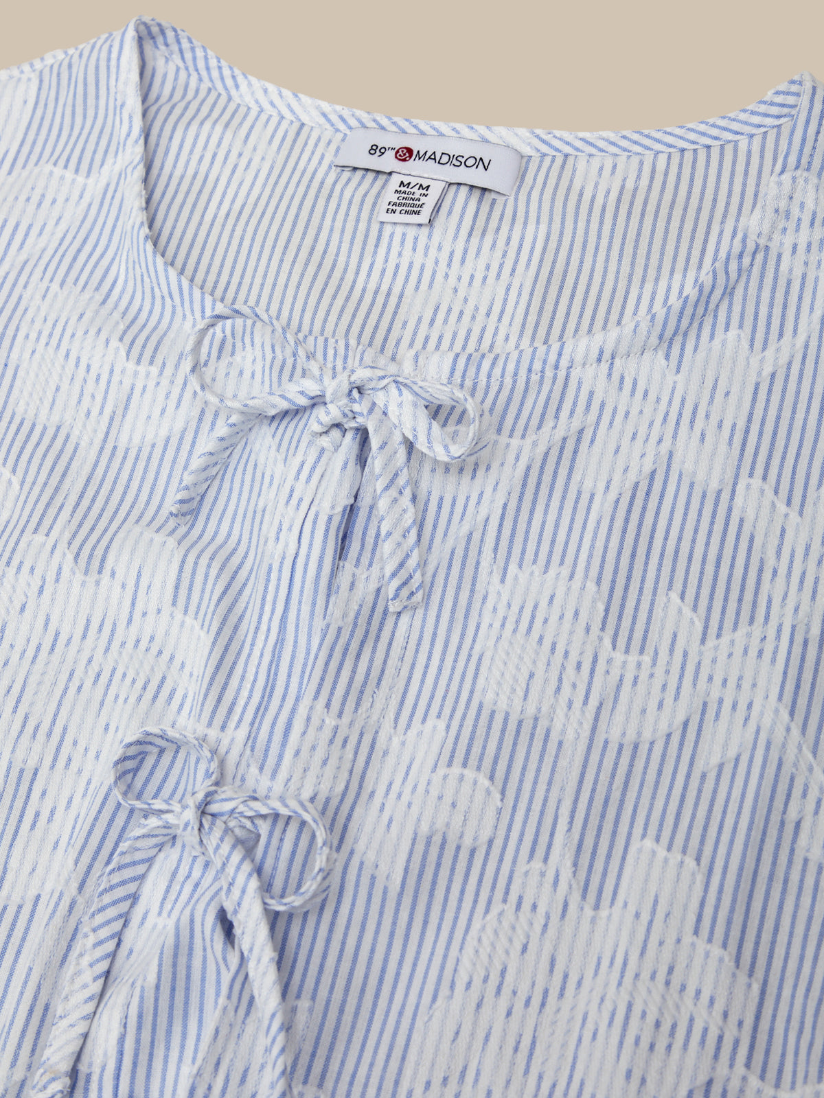 Blue and white striped shirt with floral embroidery and a bow detail, branded 'Browmiston'.
