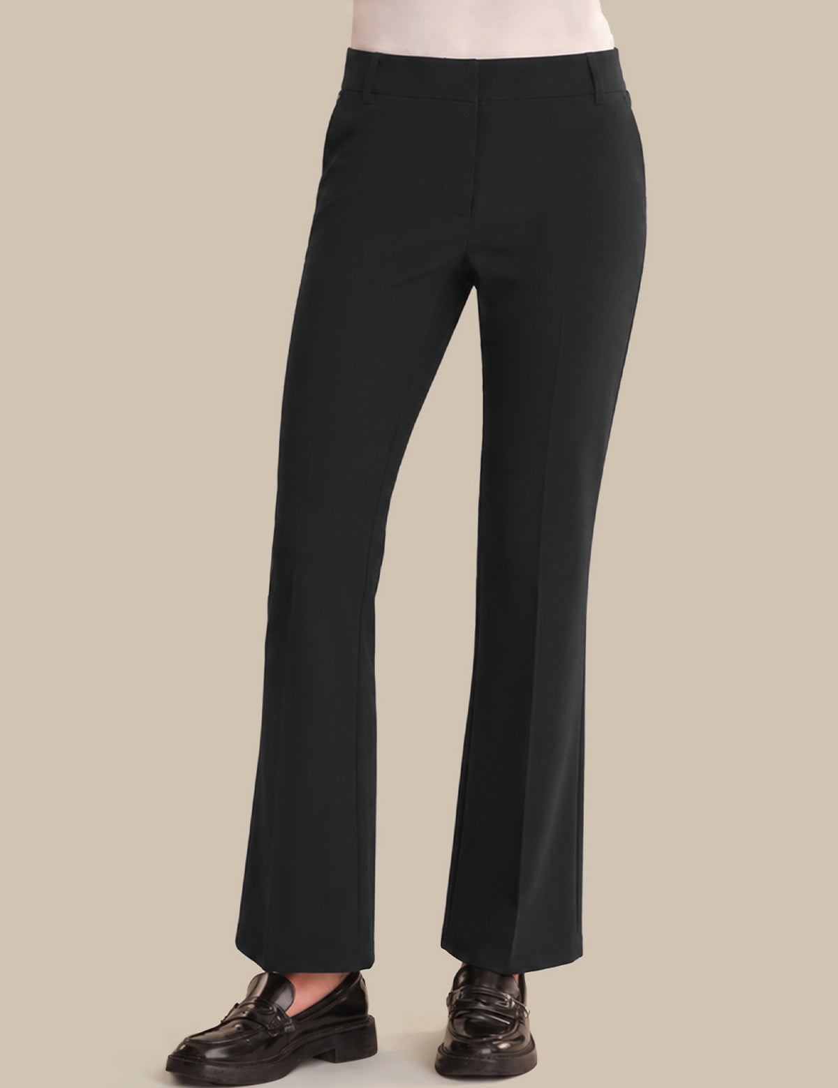 Black wide-leg trousers shown on a model from the waist down, paired with dark brown leather loafers against a solid beige background.