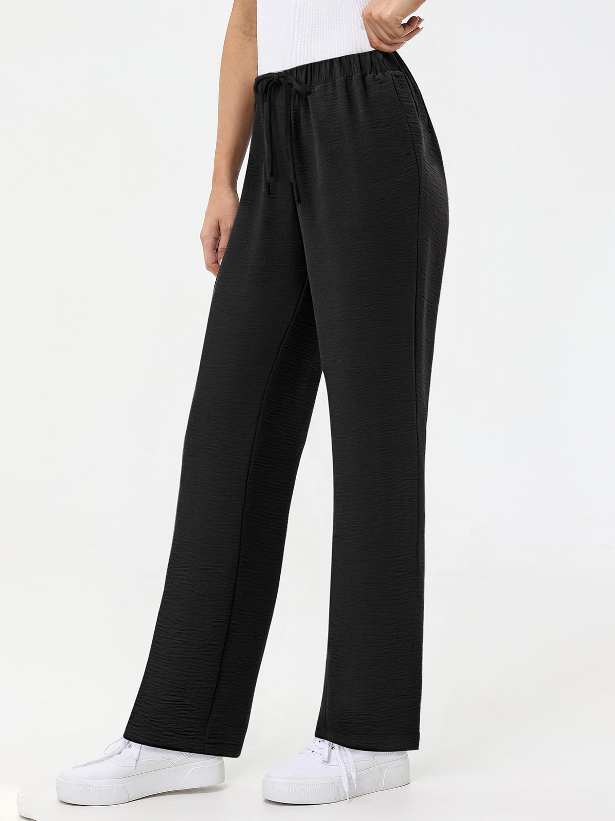 Black wide-leg pants worn by a person on a white background