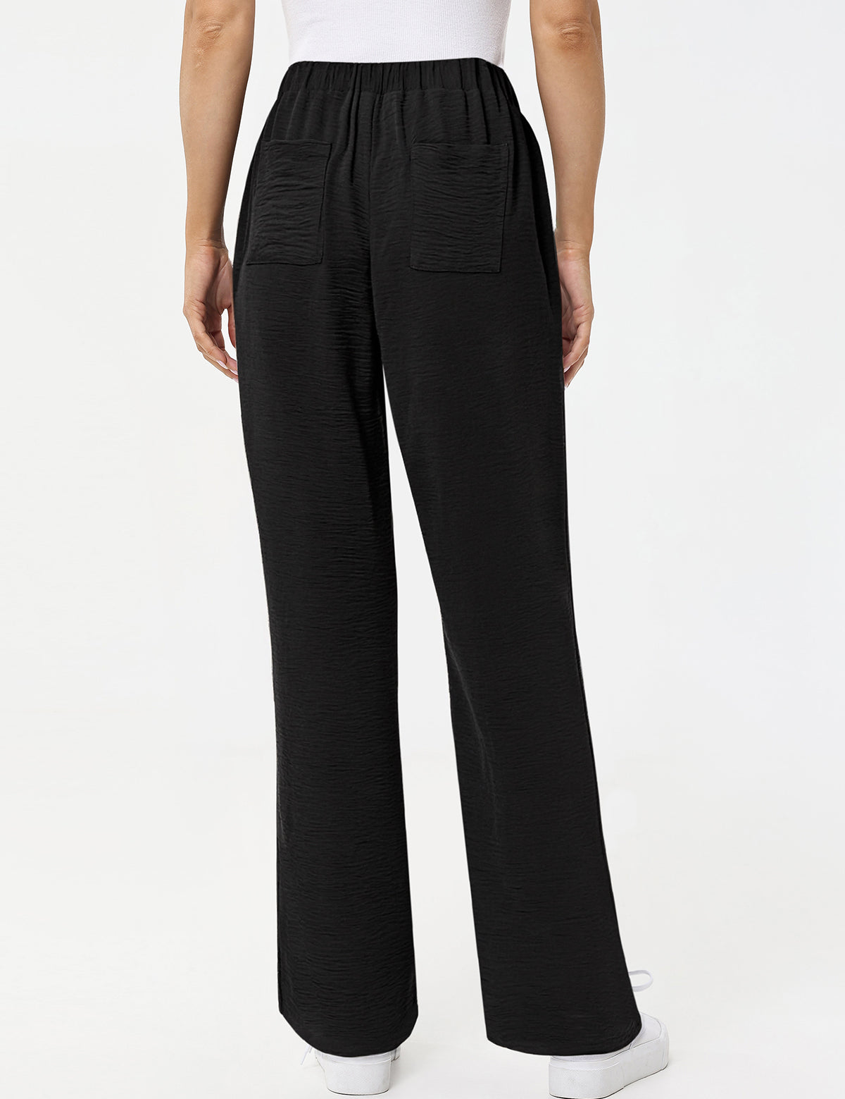 Black wide-leg pants worn by a person on a white background
