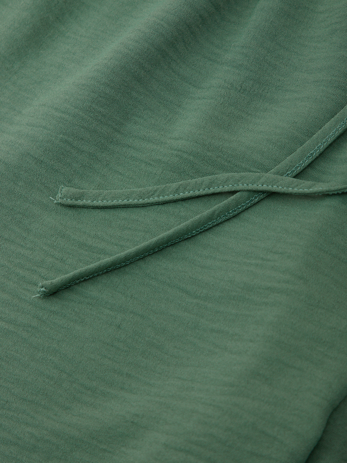 Close-up of green fabric with a visible seam