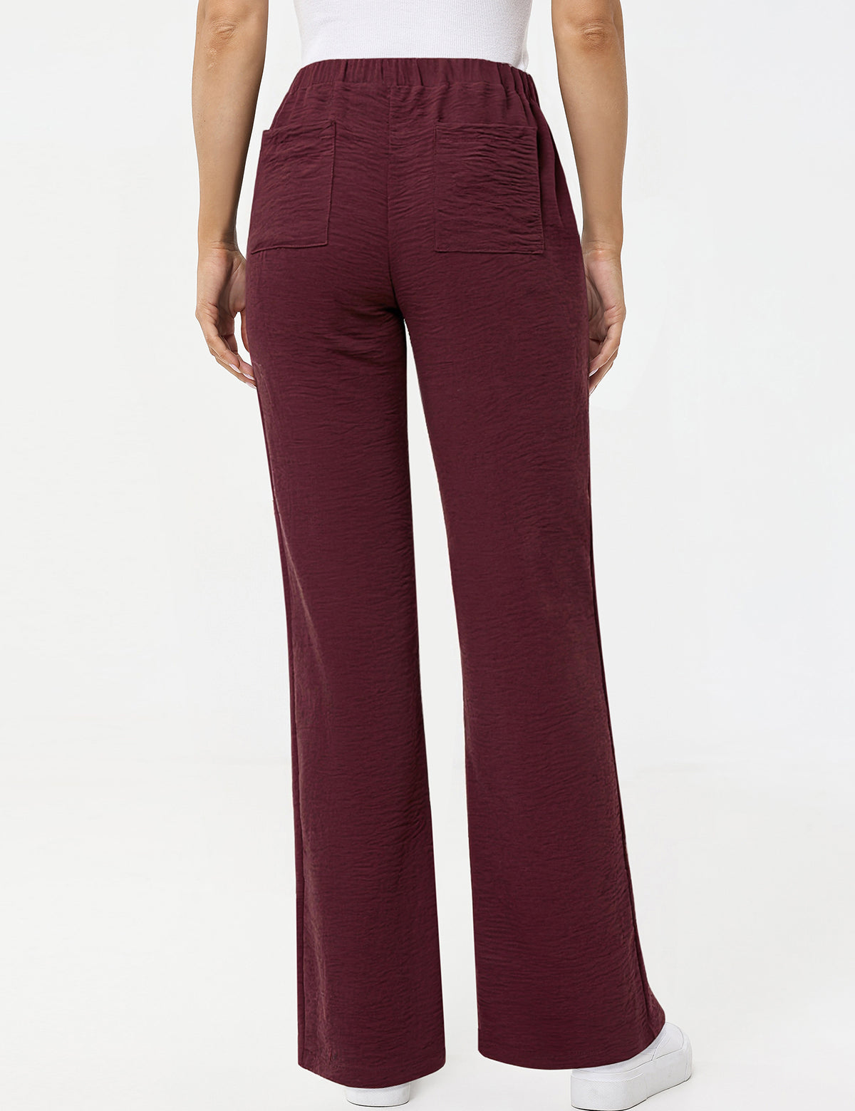 Maroon pants worn by a person on a white background