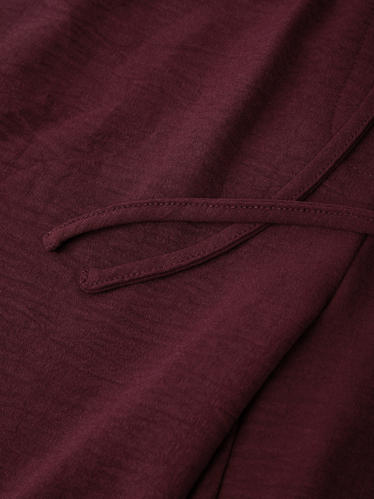 Close-up of a burgundy fabric with a tie detail
