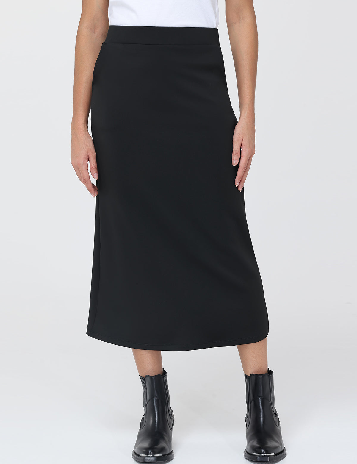 Person wearing a black skirt and black boots on a white background