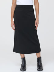 Person wearing a black skirt and black boots on a white background