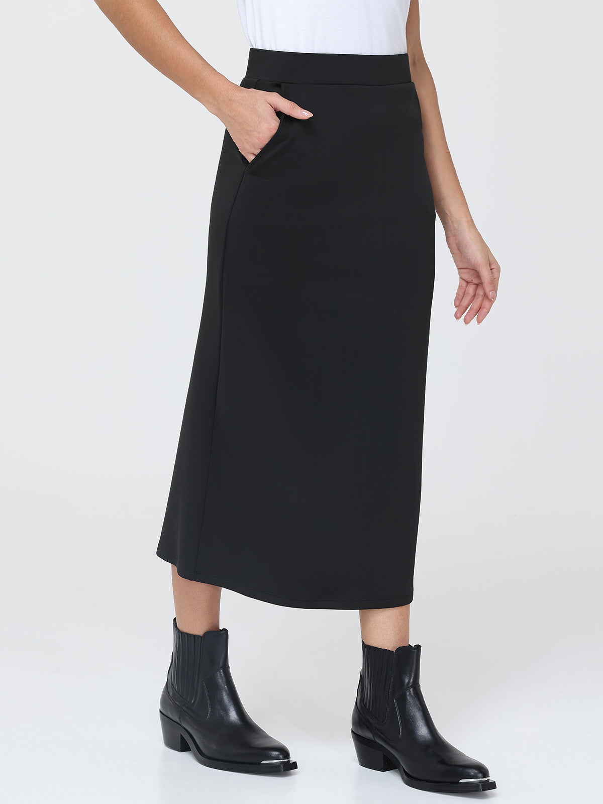 Person wearing a black skirt and black boots on a white background