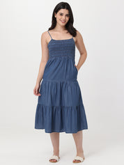 Woman wearing a blue tiered dress on a white background