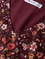 Close-up of a maroon fabric with floral patterns and a visible brand label.