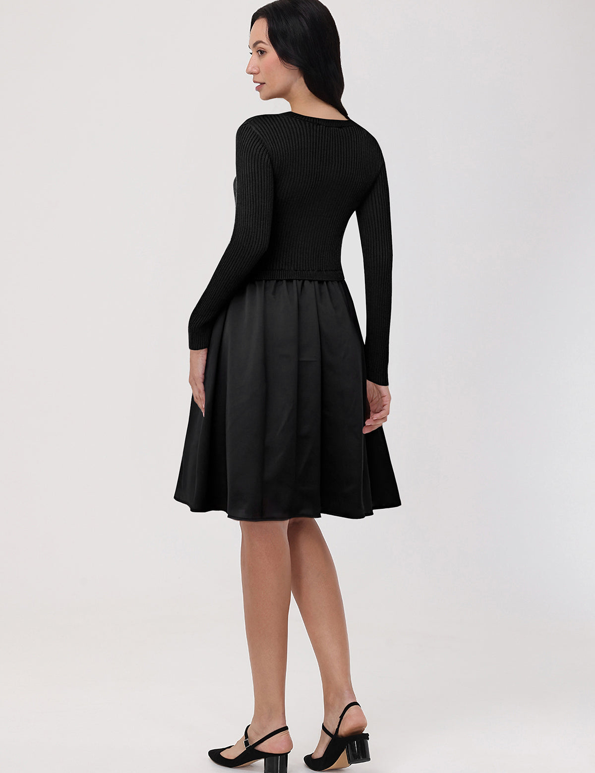 Woman wearing a black dress with a plain background