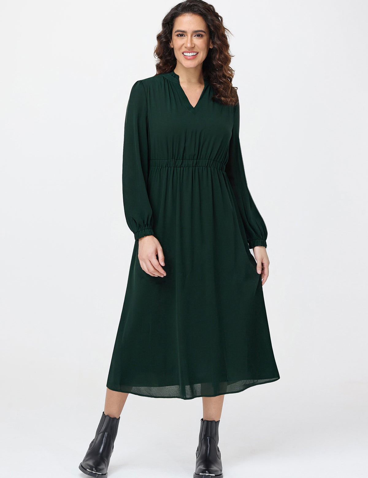 Woman wearing a green dress with long sleeves on a white background