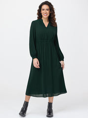 Woman wearing a green dress with long sleeves on a white background