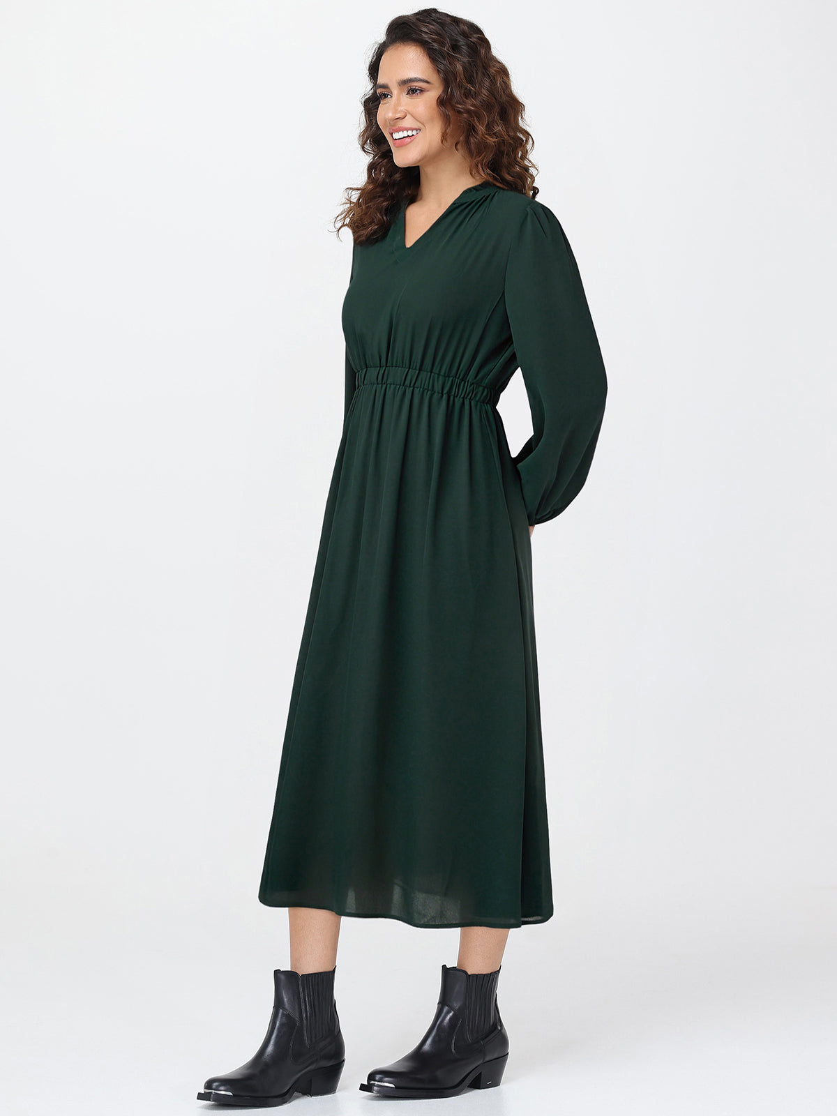Woman wearing a green dress with long sleeves on a white background