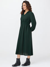 Woman wearing a green dress with long sleeves on a white background