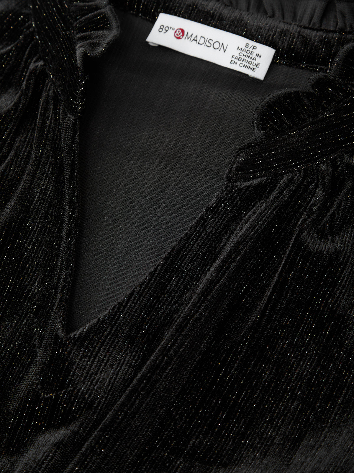 Close-up of black fabric with a brand label on a black background