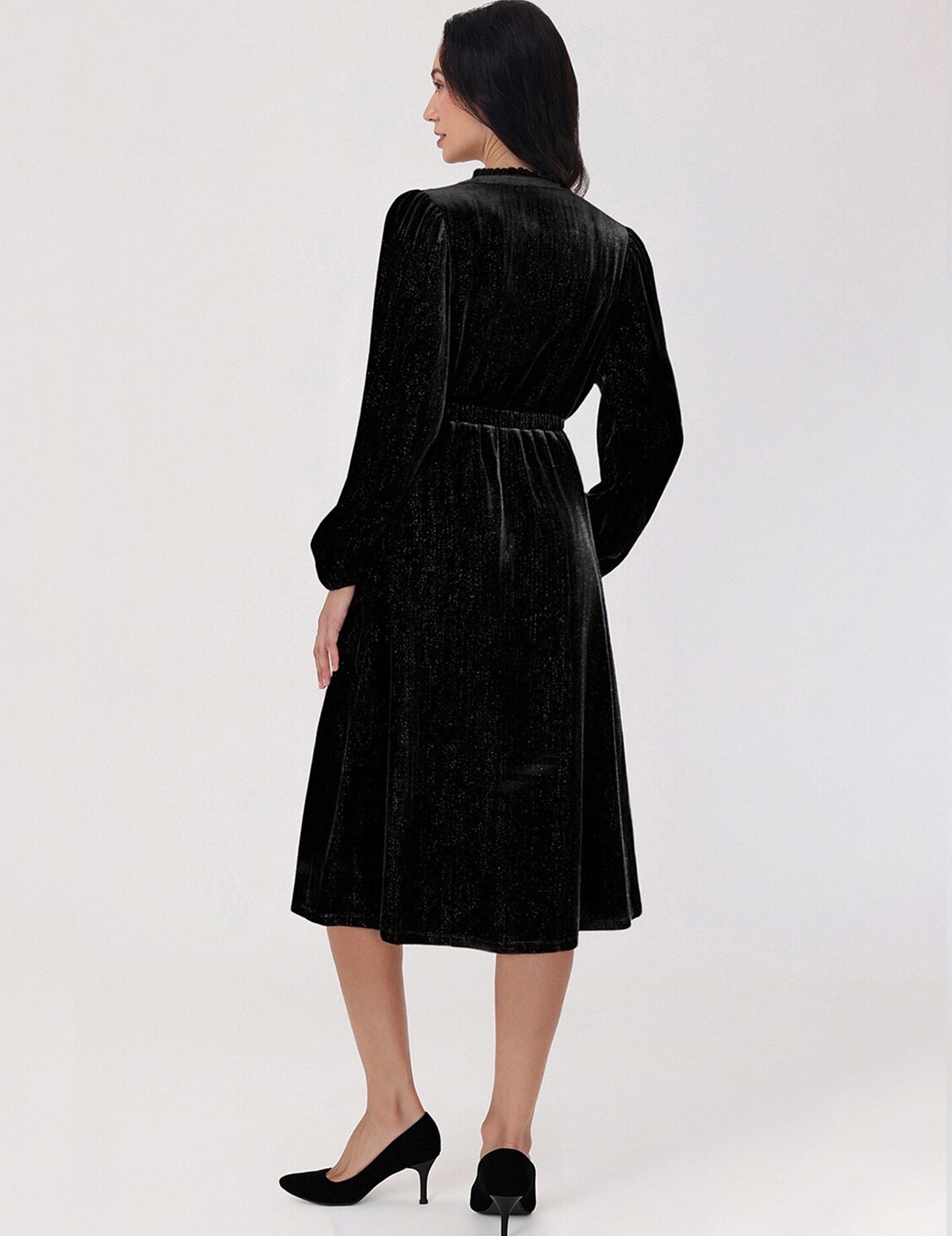 Woman wearing a black velvet dress against a white background