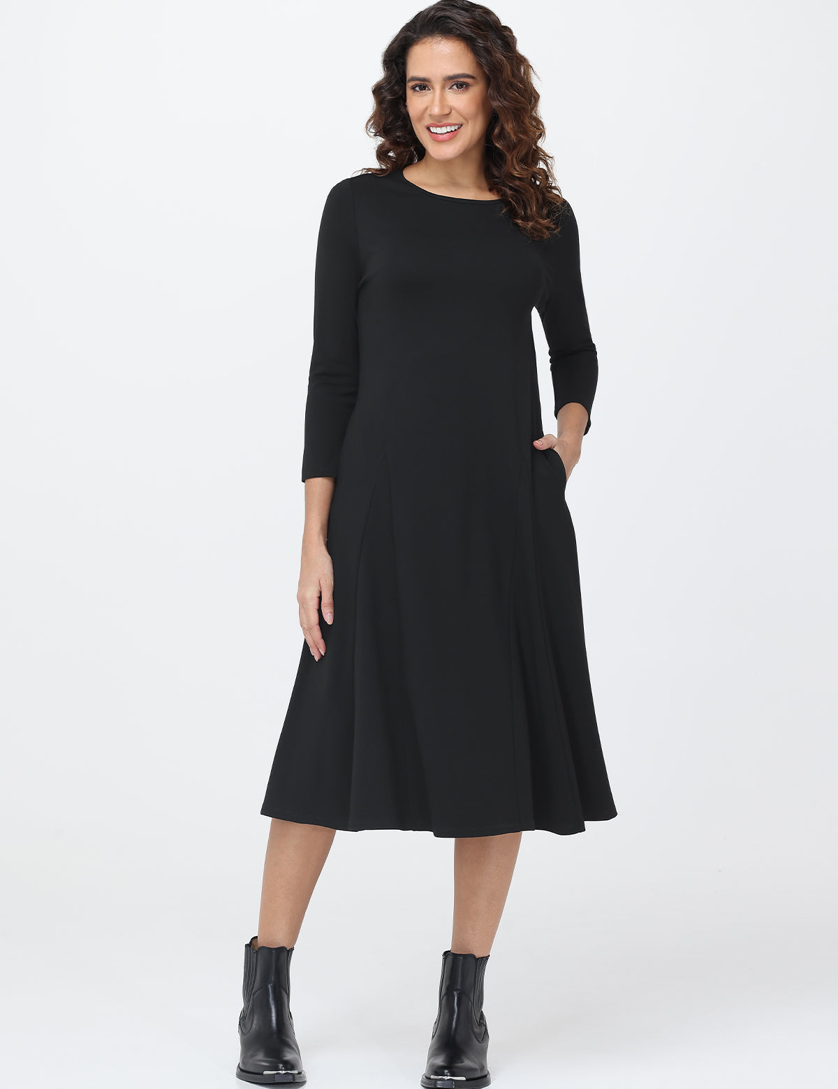 Woman wearing a black dress with long sleeves on a white background