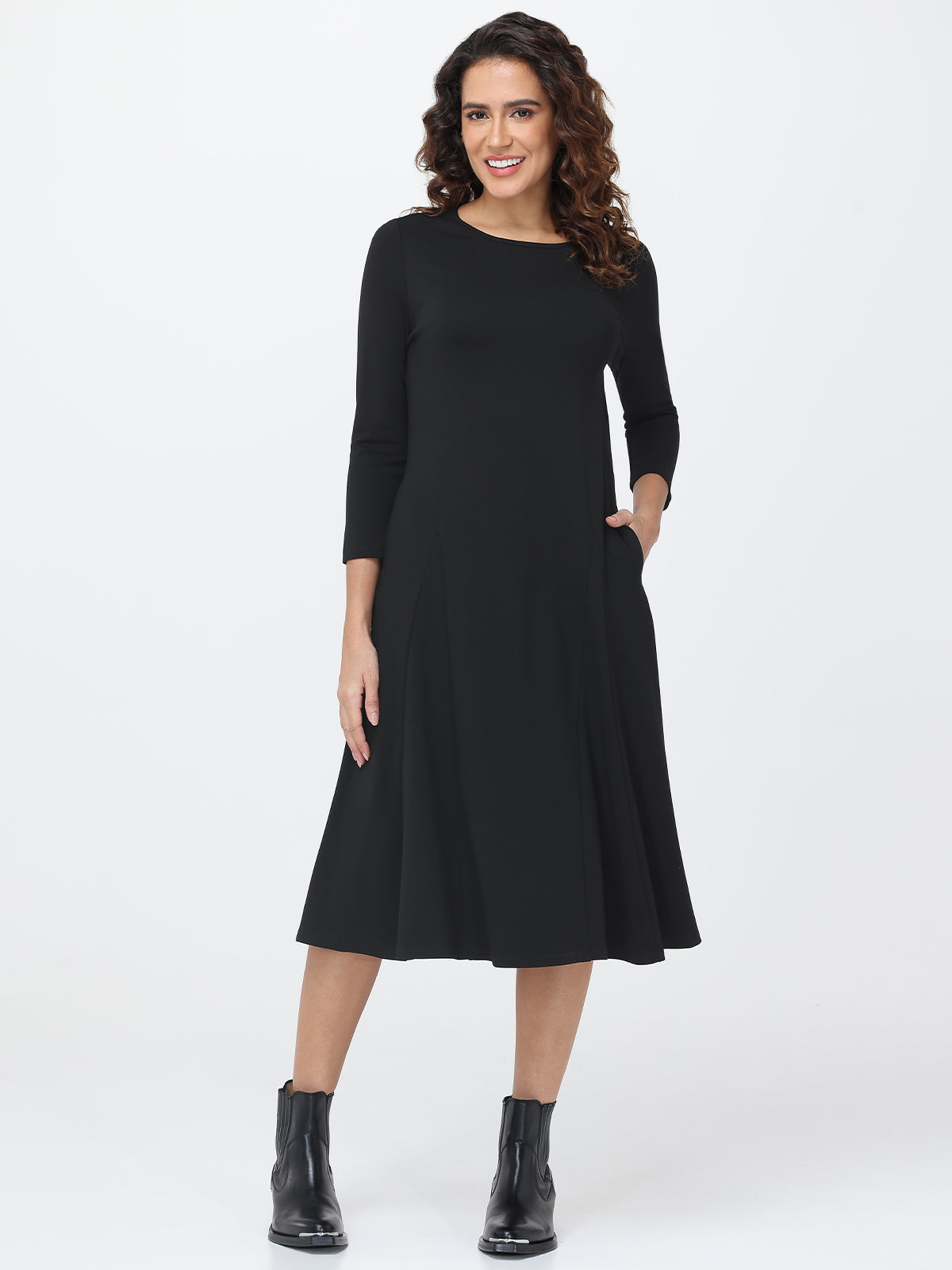 Woman wearing a black dress with long sleeves on a white background