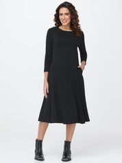 Woman wearing a black dress with long sleeves on a white background