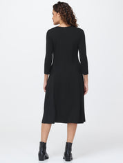 Woman wearing a black dress with long sleeves on a white background