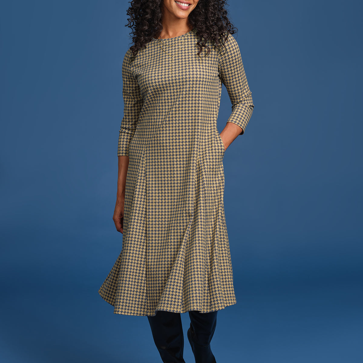 Woman wearing a plaid dress against a blue background