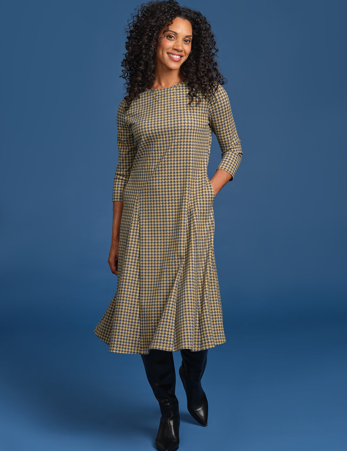 Woman wearing a plaid dress against a blue background