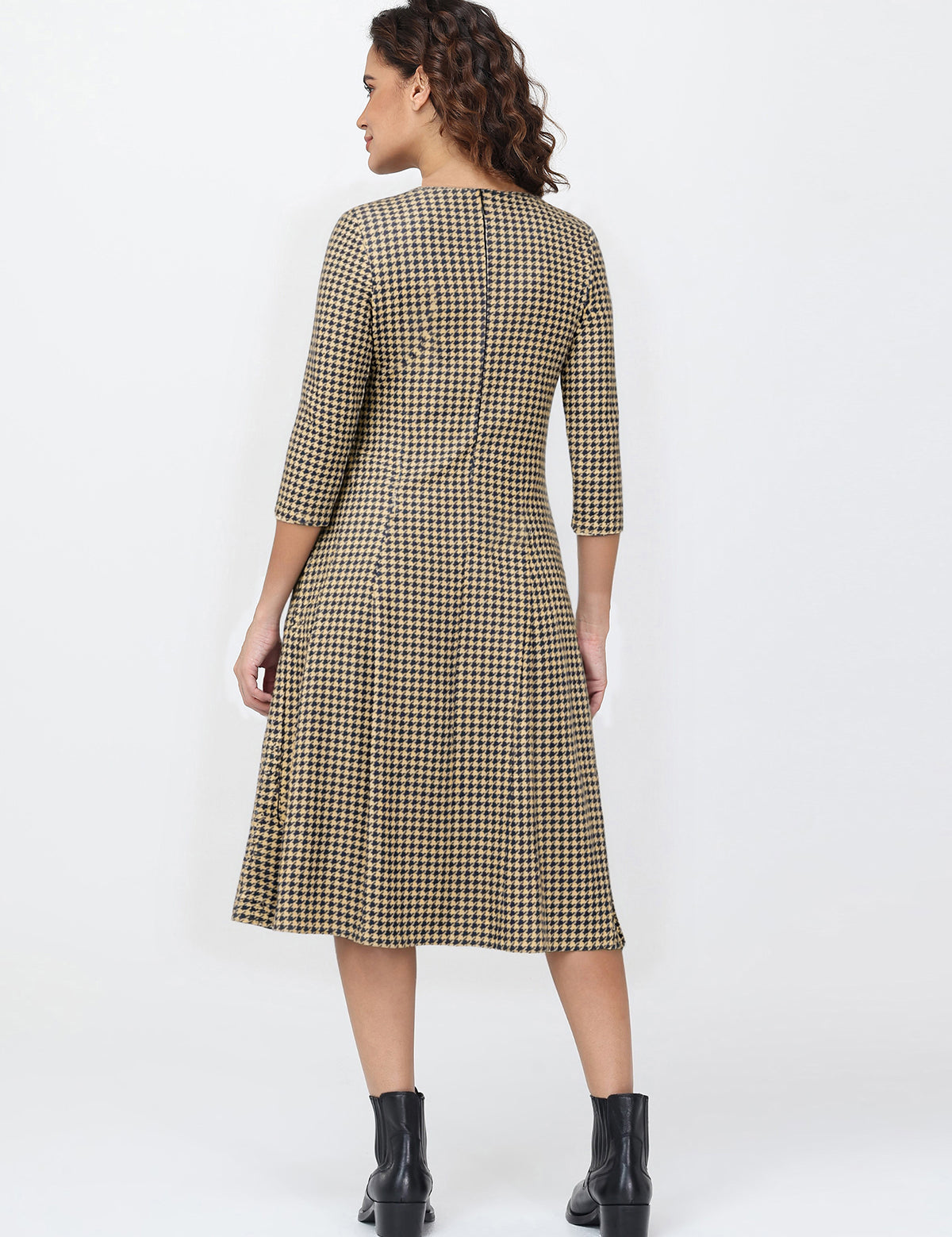 Woman wearing a plaid dress with a white background