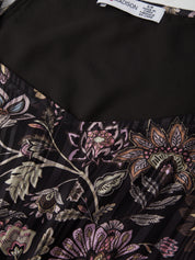 Close-up of a black fabric with floral patterns and a visible label.