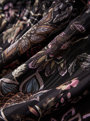 Close-up of patterned fabric with floral and leaf designs on a black background