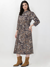 Woman wearing a patterned dress with brown boots on a white background