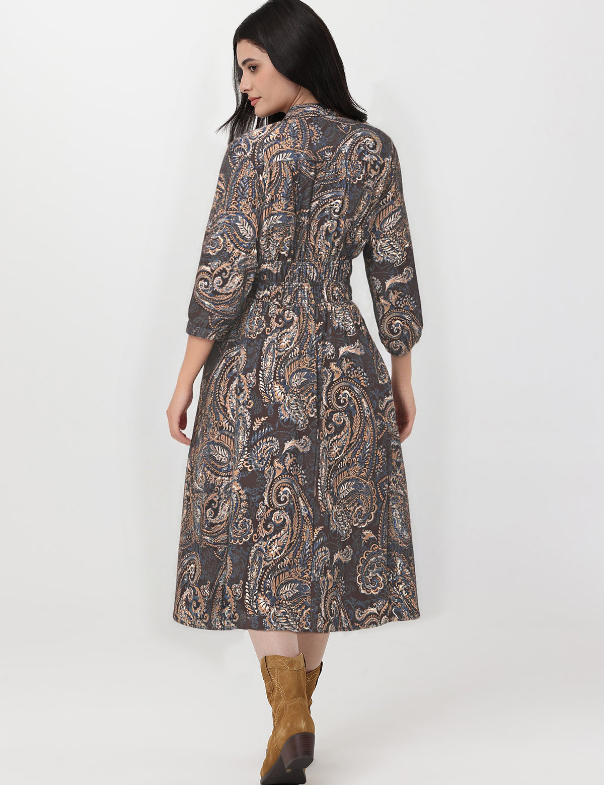 Woman wearing a patterned dress with long sleeves on a white background