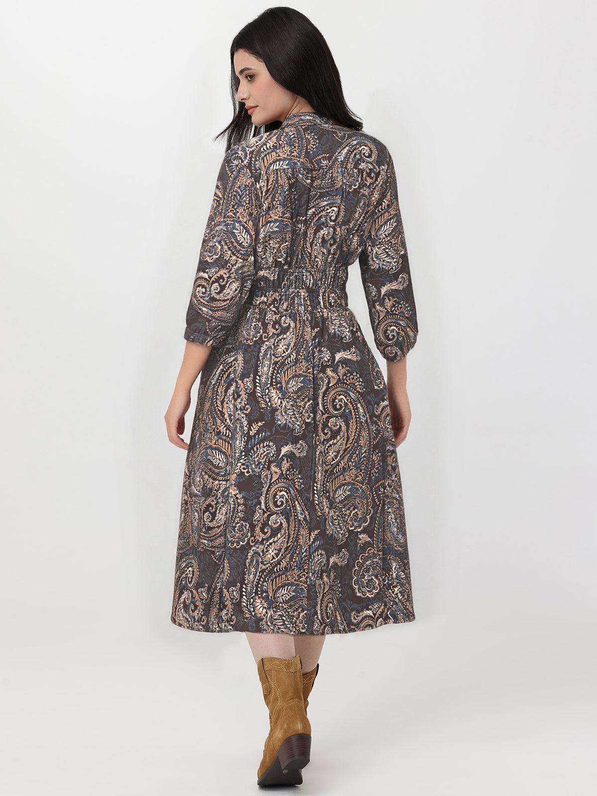 Woman wearing a patterned dress with long sleeves on a white background