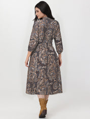 Woman wearing a patterned dress with long sleeves on a white background