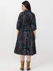 Woman wearing a patterned dress with a white background