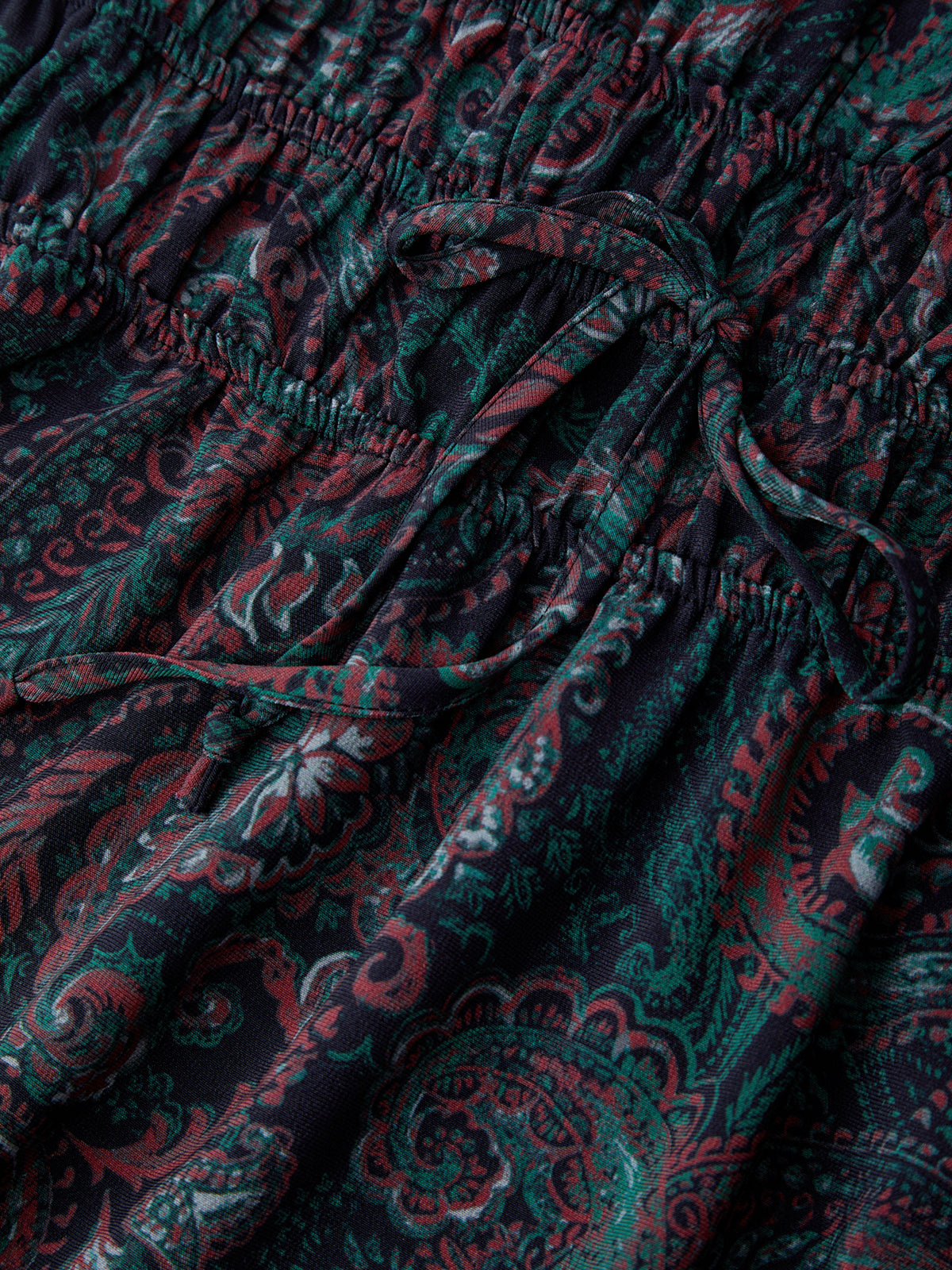 Close-up of dark fabric with red and green paisley pattern