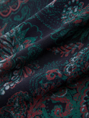 Close-up of patterned fabric with red and green design on a dark background