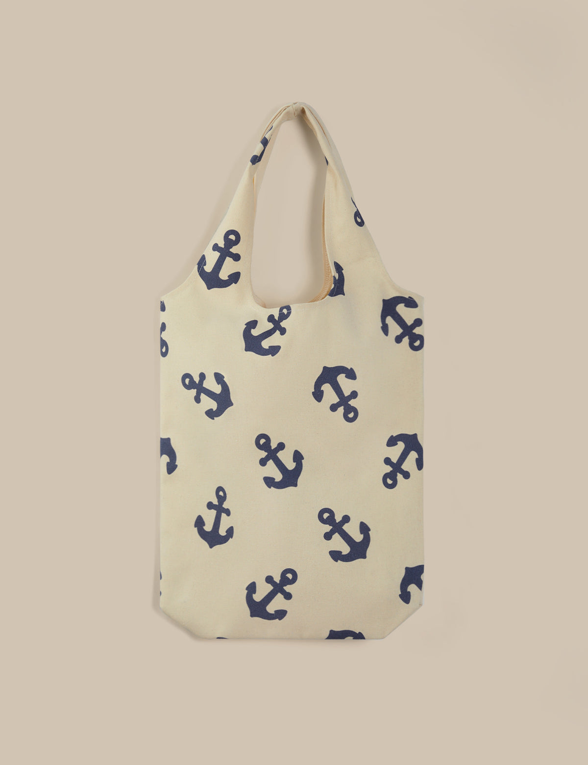 Beige tote bag with blue anchor pattern on a beige background