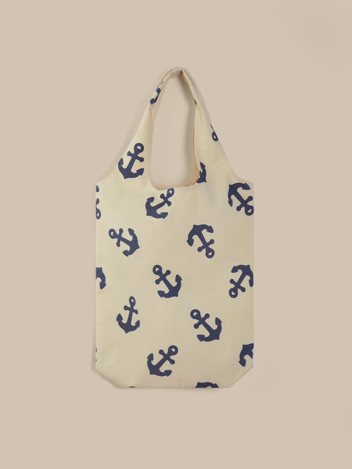 Beige tote bag with blue anchor pattern on a beige background