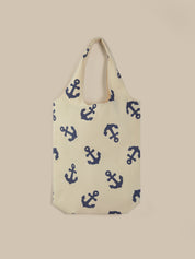 Beige tote bag with blue anchor pattern on a beige background