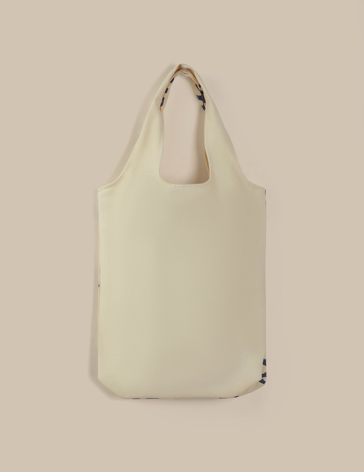 Light green tote bag with a strap on a beige background