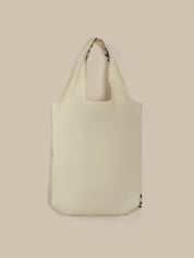 Light green tote bag with a strap on a beige background