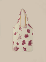 Tote bag with red shell pattern on a beige background