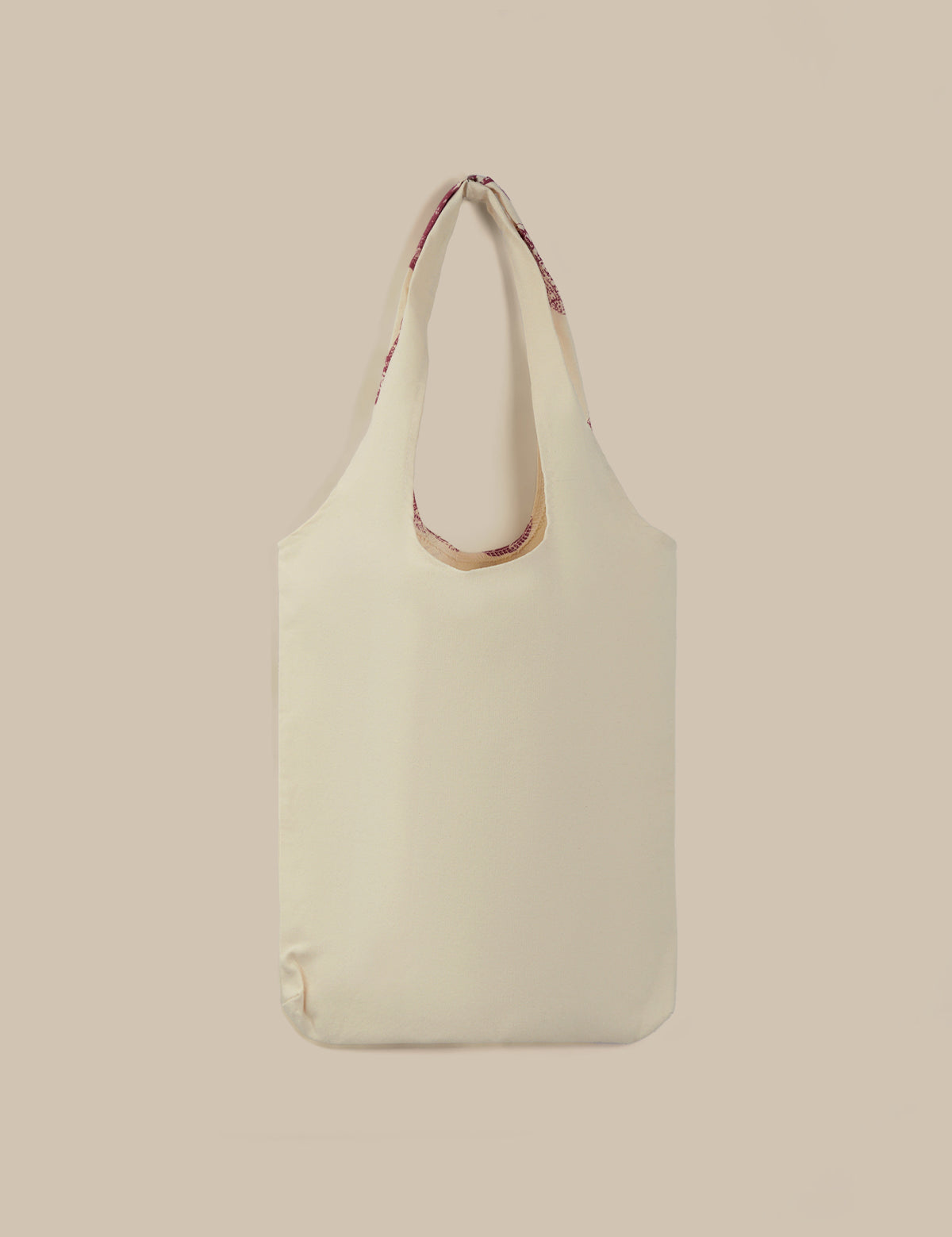Beige tote bag with a strap on a beige background