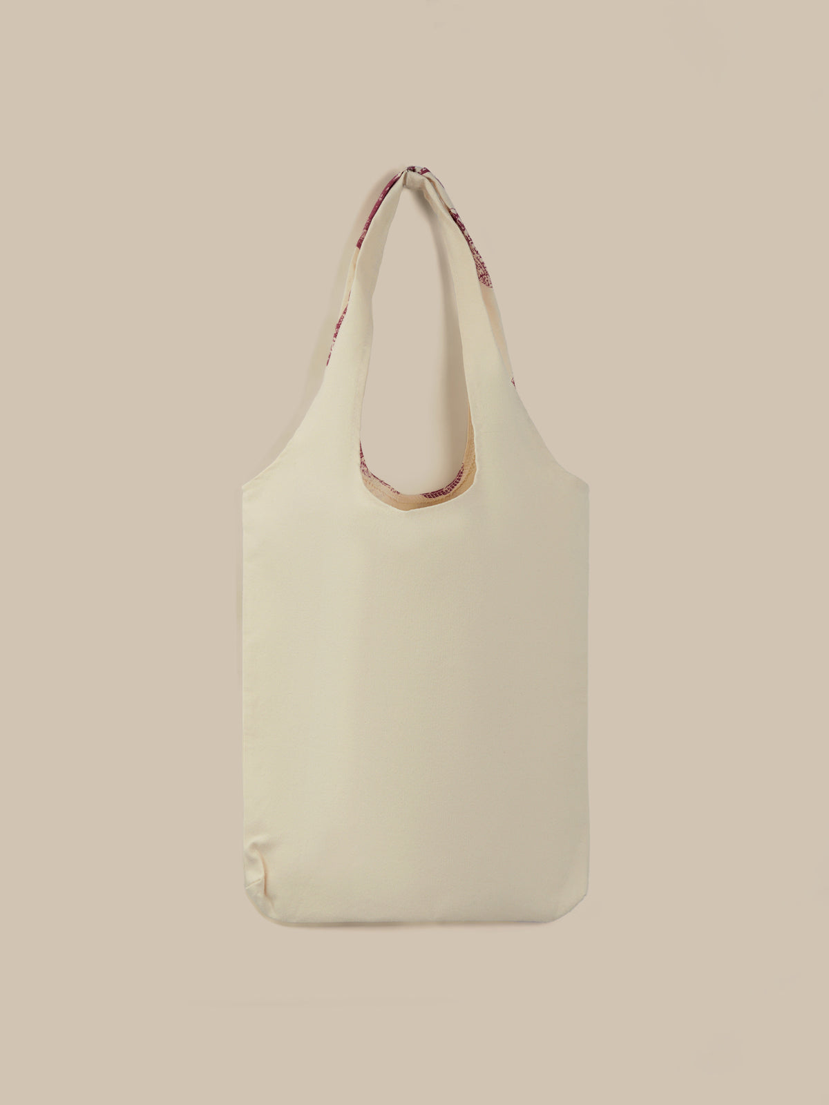 Beige tote bag with a strap on a beige background