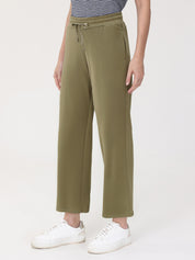 Person wearing olive green wide-leg pants with a white background