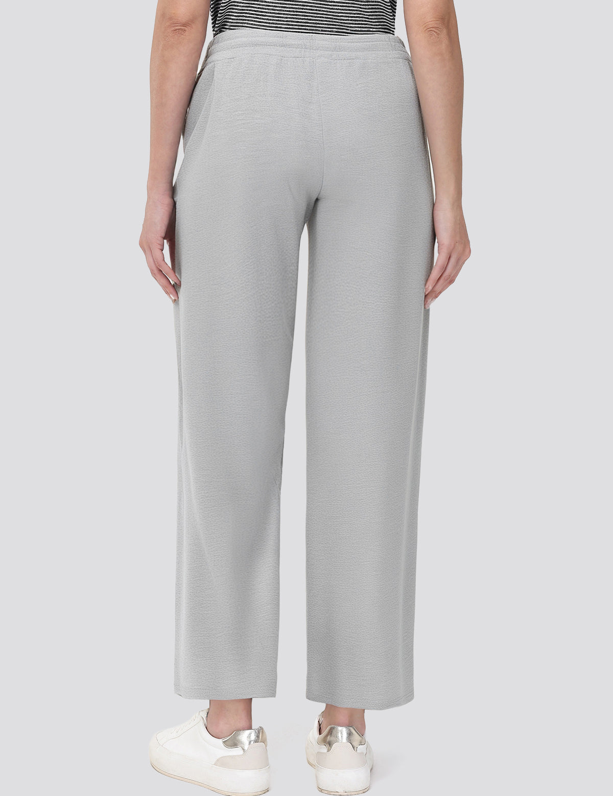 Person wearing light gray wide-leg pants on a white background